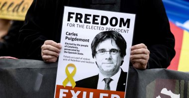 A demonstrator holds a flyer depicting former Catalan leader Carles Puigdemont during a demonstration near the European Parliament in Brussels, Belgium, Sept. 24, 2021. (AFP Photo)