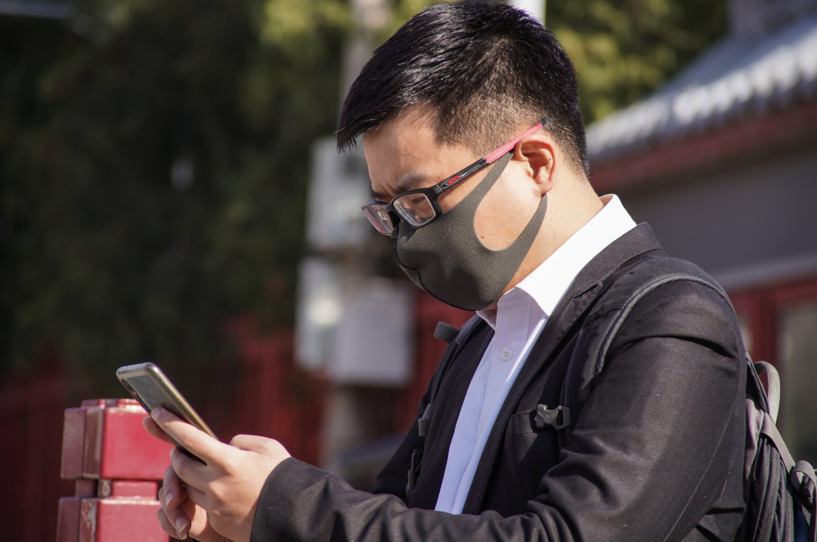 A man wearing a face mask uses his mobile phone in Beijing, China, March 14, 2022. (EPA Photo)