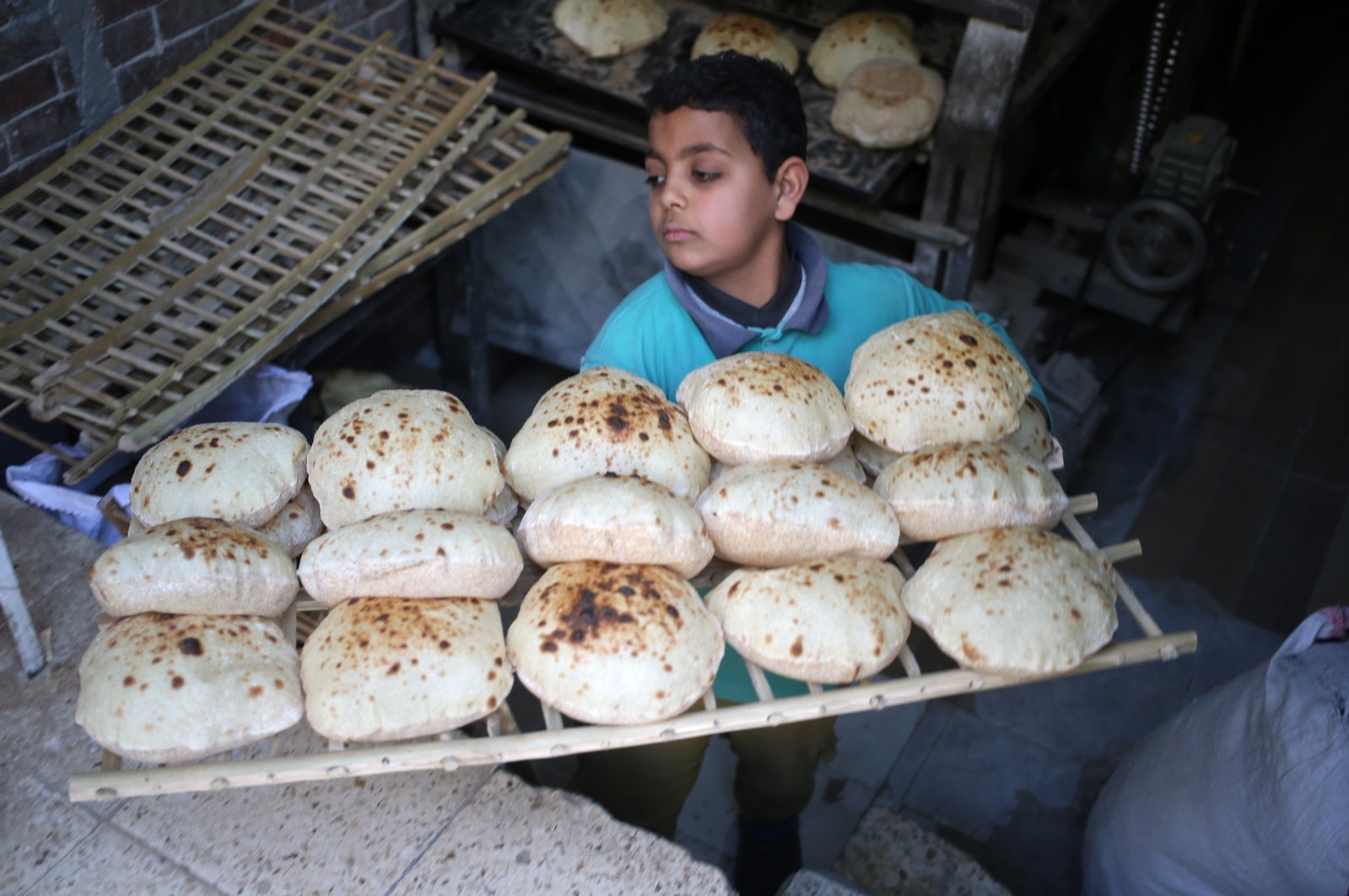 An Egyptian baker carries bread at a bakery in Cairo, Egypt, March 3, 2022. (EPA Photo)