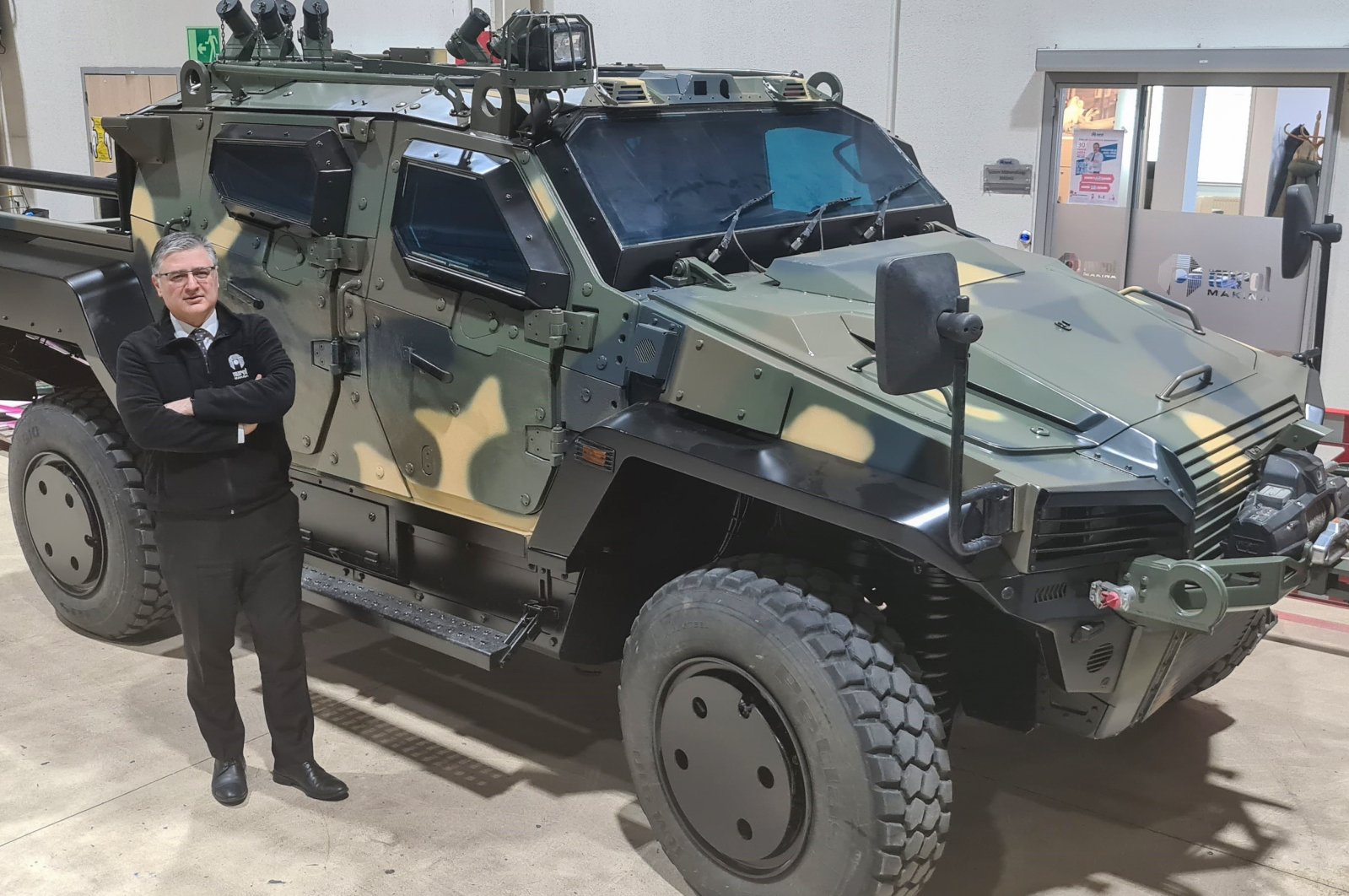 Nurol Makina General Manager Engin Aykol poses with a 4x4 tactical wheeled armored vehicles produced by company, Ankara, Turkey, March 17, 2022. (AA Photo) 