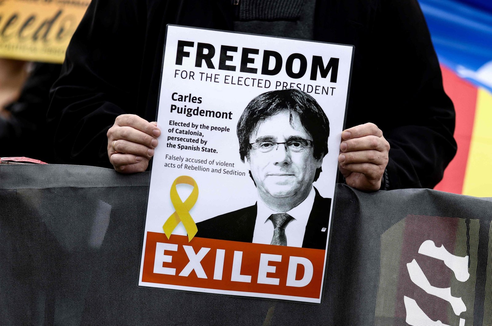 A demonstrator holds a flyer depicting former Catalan leader Carles Puigdemont during a demonstration near the European Parliament in Brussels, Belgium, Sept. 24, 2021. (AFP Photo)
