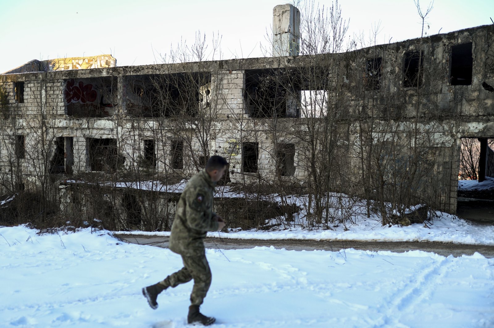 A soldier walks by an abandoned building destroyed during the Bosnian War on Mount Trebevic near the capital Sarajevo, Bosnia-Herzegovina, March 3, 2022. (AP Photo)