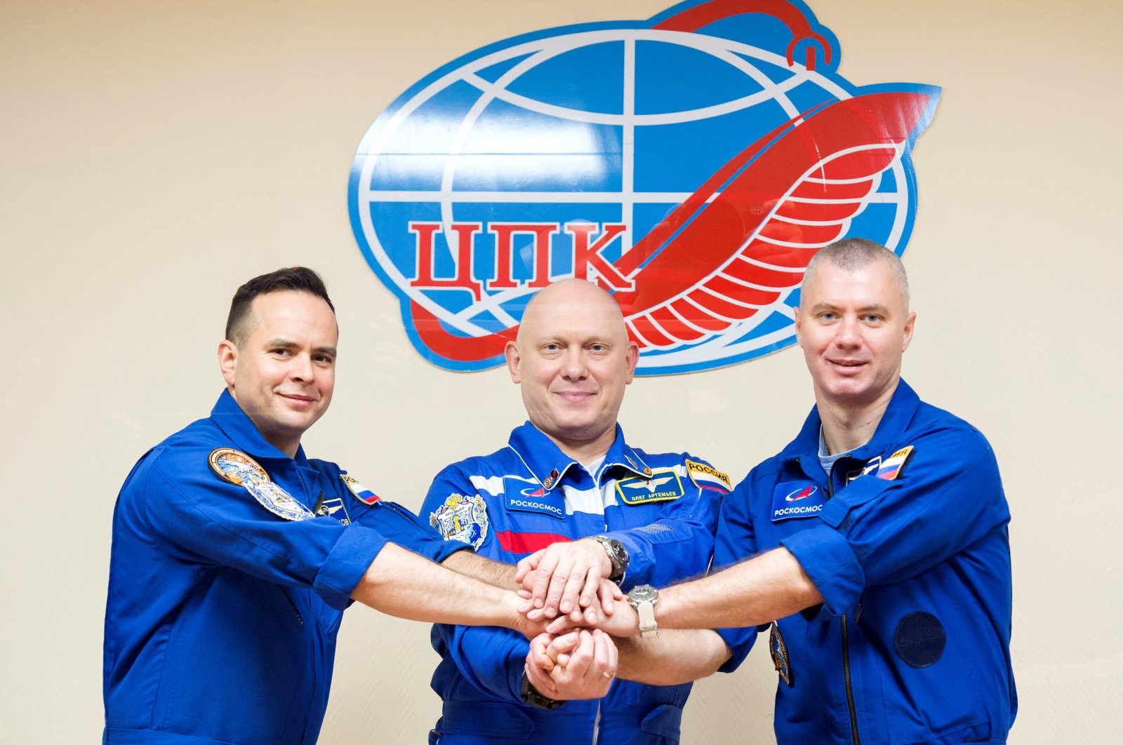 Left to right, Russian cosmonauts Oleg Artemyev, Denis Matveev and Sergey Korsakov pose for a picture during a news conference ahead of the expedition to the International Space Station (ISS) at the Baikonur Cosmodrome, Kazakhstan, March 17, 2022. (Roscosmos Handout via Reuters)