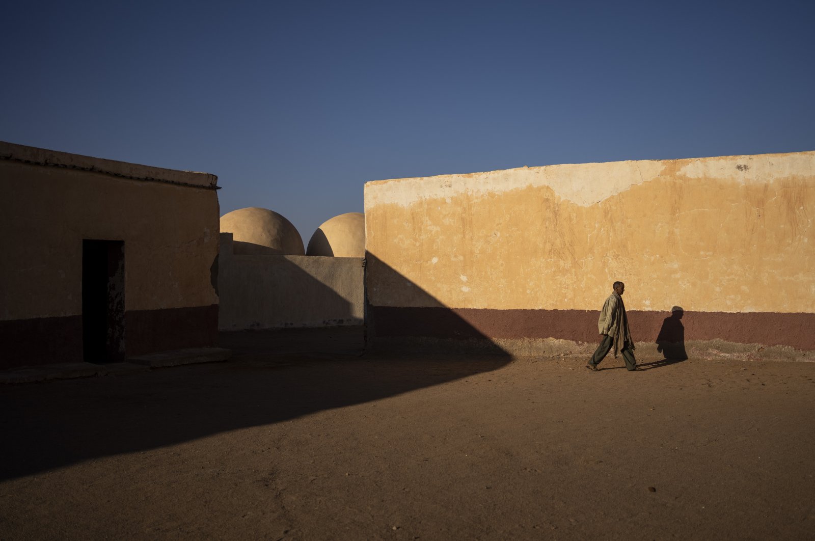 A Sahrawi man walks on the patio of a closed school in Bir Lahlou, Western Sahara, Oct. 13, 2021. (AP Photo)