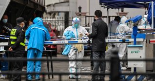 A delivery man (L in blue) is seen arriving to deliver an order outside of a locked-down neighborhood after the detection of new cases of COVID-19 in Huangpu district, in Shanghai, China, March 17, 2022. (AFP Photo)
