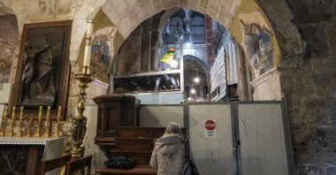 A member of the restoration team works on the floor of the Church of the Holy Sepulchre, where many Christians believe Jesus was crucified, buried and rose from the dead, in the Old City of Jerusalem, Palestine, March 17, 2022. (AP Photo)