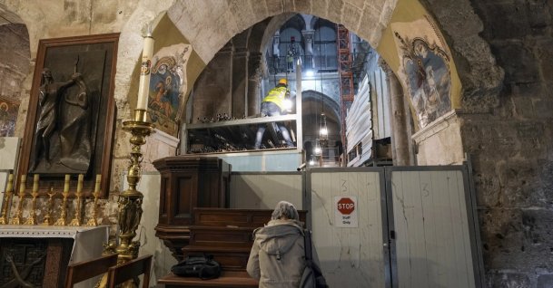 A member of the restoration team works on the floor of the Church of the Holy Sepulchre, where many Christians believe Jesus was crucified, buried and rose from the dead, in the Old City of Jerusalem, Palestine, March 17, 2022. (AP Photo)