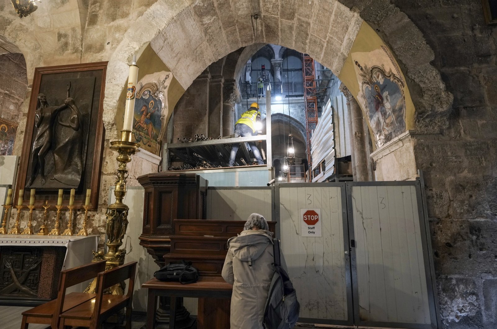 A member of the restoration team works on the floor of the Church of the Holy Sepulchre, where many Christians believe Jesus was crucified, buried and rose from the dead, in the Old City of Jerusalem, Palestine, March 17, 2022. (AP Photo)