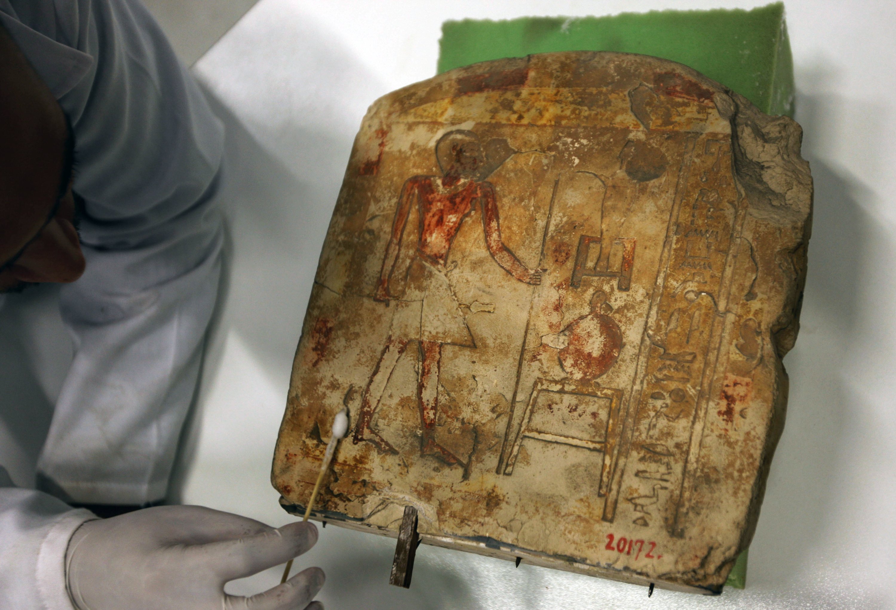 An Egyptian archaeologist works on a pharaonic late                period round-topped stela of Sobck Nakht in the stone                laboratory of the newly opened restoration center of the                partially opened complex of the Grand Egyptian Museum in                Cairo, Egypt, June 16, 2010. (AP Photo)