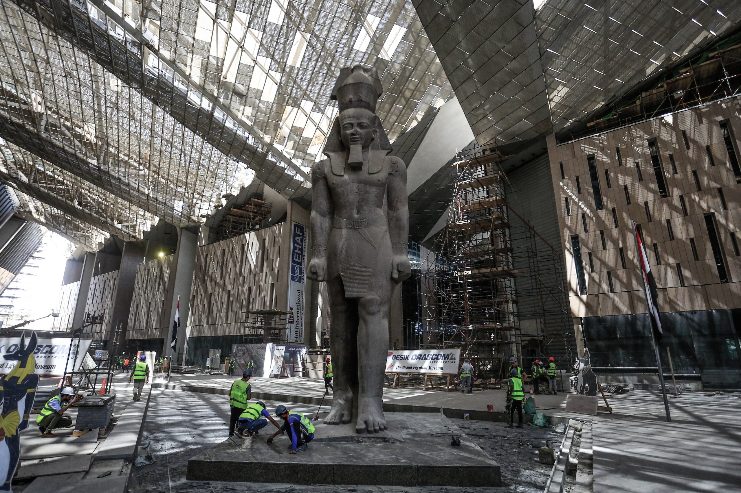 Workers clean the area next to a giant statue of the                Egyptian pharaoh Ramses II in the hall of the Grand                Egyptian Museum in Giza outside Cairo. (DPA)