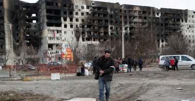 People gather near a block of flats, which was destroyed during the Russian invasion of Ukraine in the besieged southern port city of Mariupol, Ukraine, March 17, 2022. (REUTERS Photo)