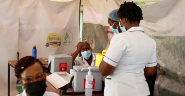A health worker waits to get a booster shot vaccine against COVID-19 in a makeshift tent at a medical clinic in Nairobi, Kenya, Jan. 19, 2022. (REUTERS)
