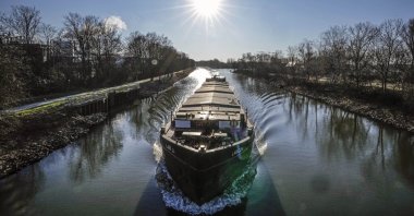 A freight ship operates on a canal on a sunny Tuesday, Gelsenkirchen, Germany, March 8, 2022. (AP Photo)