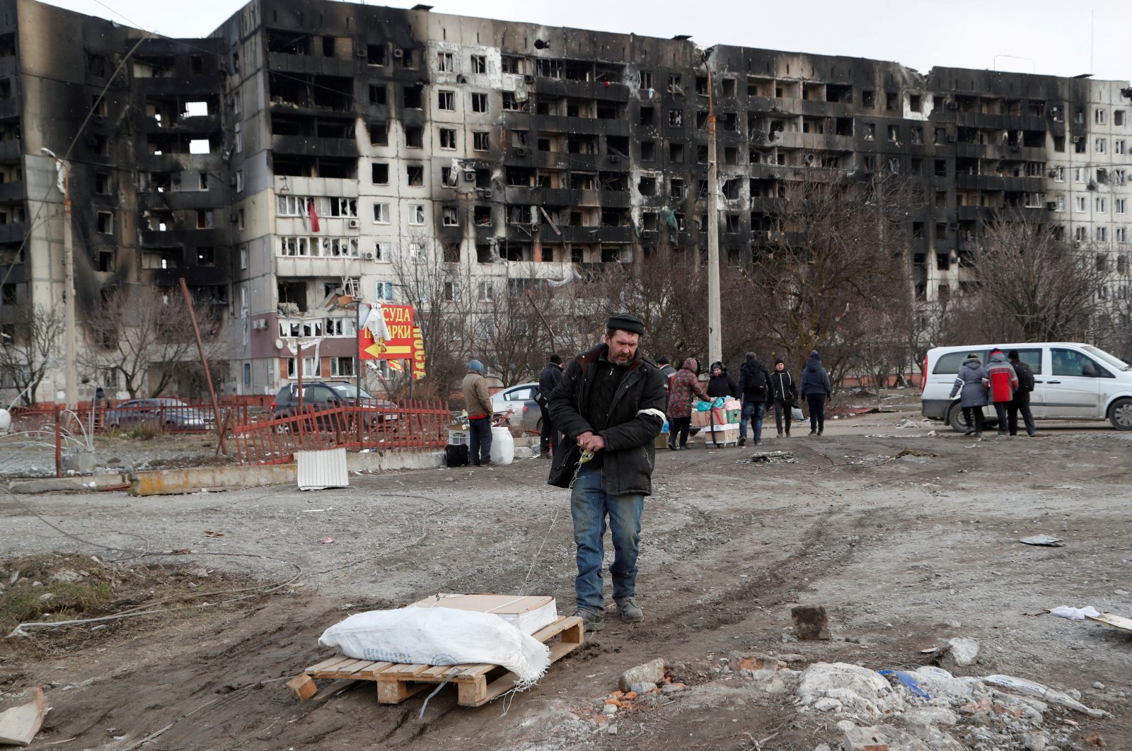 People gather near a block of flats, which was destroyed during the Russian invasion of Ukraine in the besieged southern port city of Mariupol, Ukraine, March 17, 2022. (REUTERS Photo)