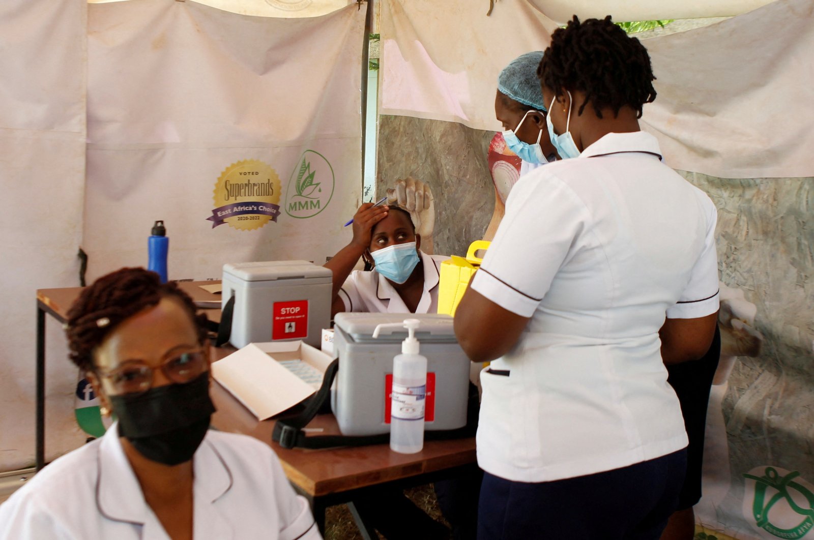 A health worker waits to get a booster shot vaccine against COVID-19 in a makeshift tent at a medical clinic in Nairobi, Kenya, Jan. 19, 2022. (REUTERS)