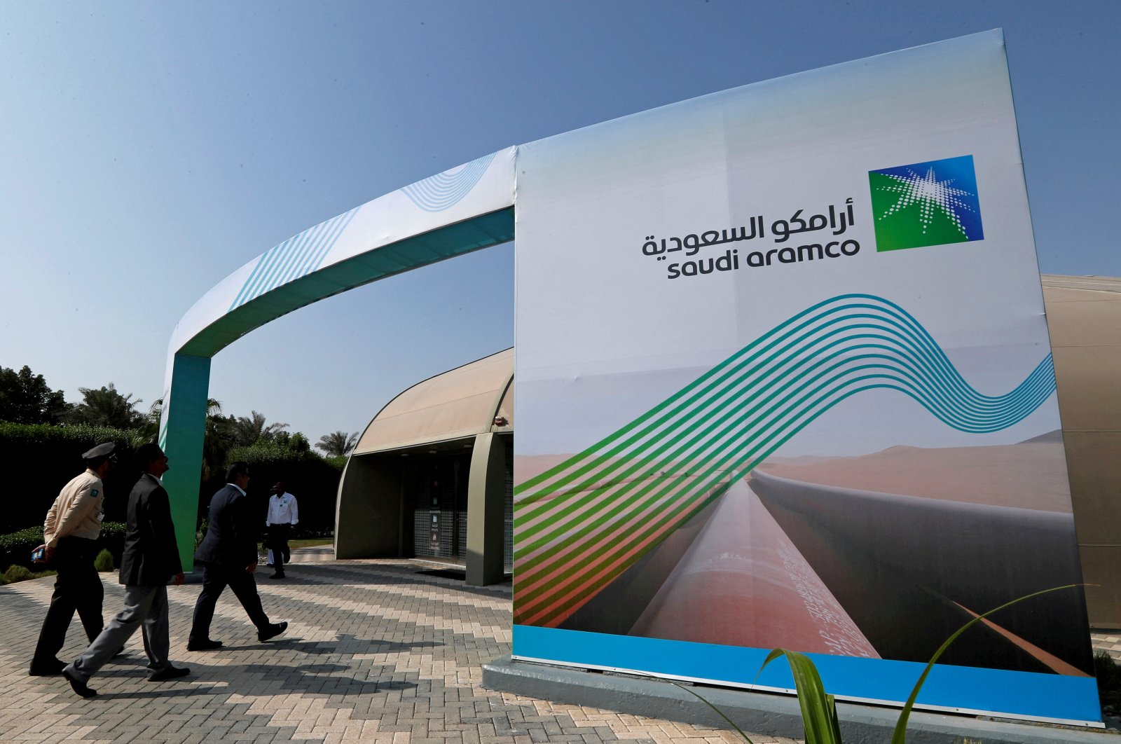 The logo of Aramco is seen as security personnel walk before the start of a press conference by Aramco at the Plaza Conference Center in Dhahran, Saudi Arabia, Nov. 3, 2019. (Reuters Photo)