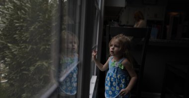 Alyssa Carpenter, 2, looks out of a window of her home in Haymarket, Virginia, U.S., Jan. 28, 2022. (AP Photo)