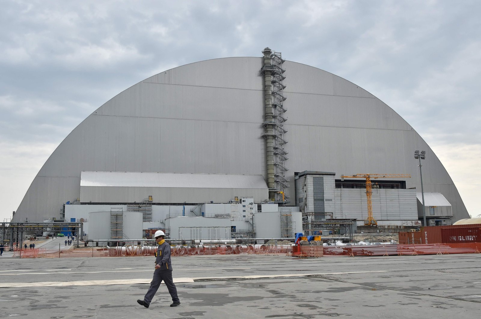 Workers walk next to the new safe confinement over the fourth block of the Chernobyl nuclear plant, Ukraine, April 26, 2017. (AFP Photo)