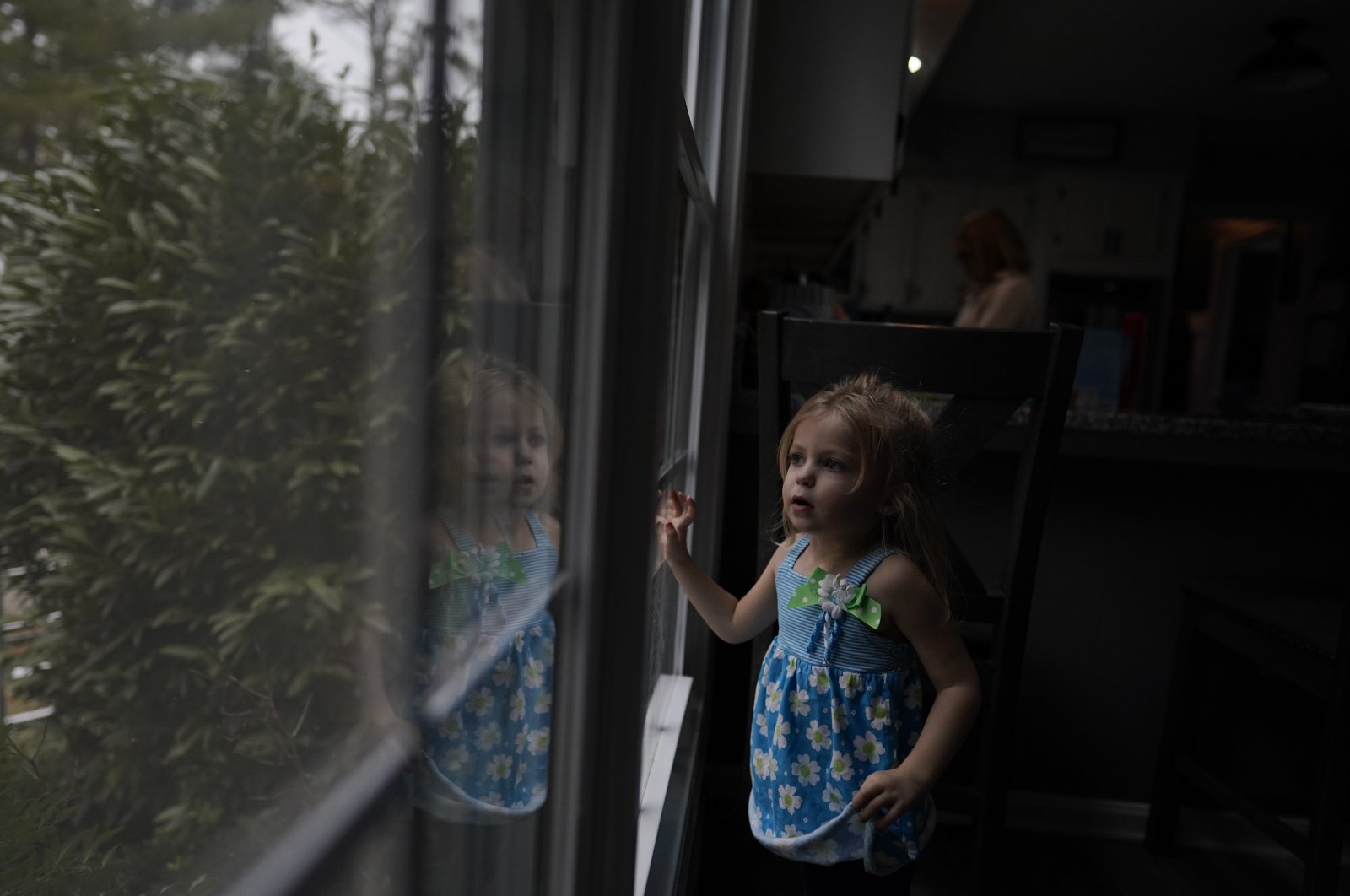 Alyssa Carpenter, 2, looks out of a window of her home in Haymarket, Virginia, U.S., Jan. 28, 2022. (AP Photo)