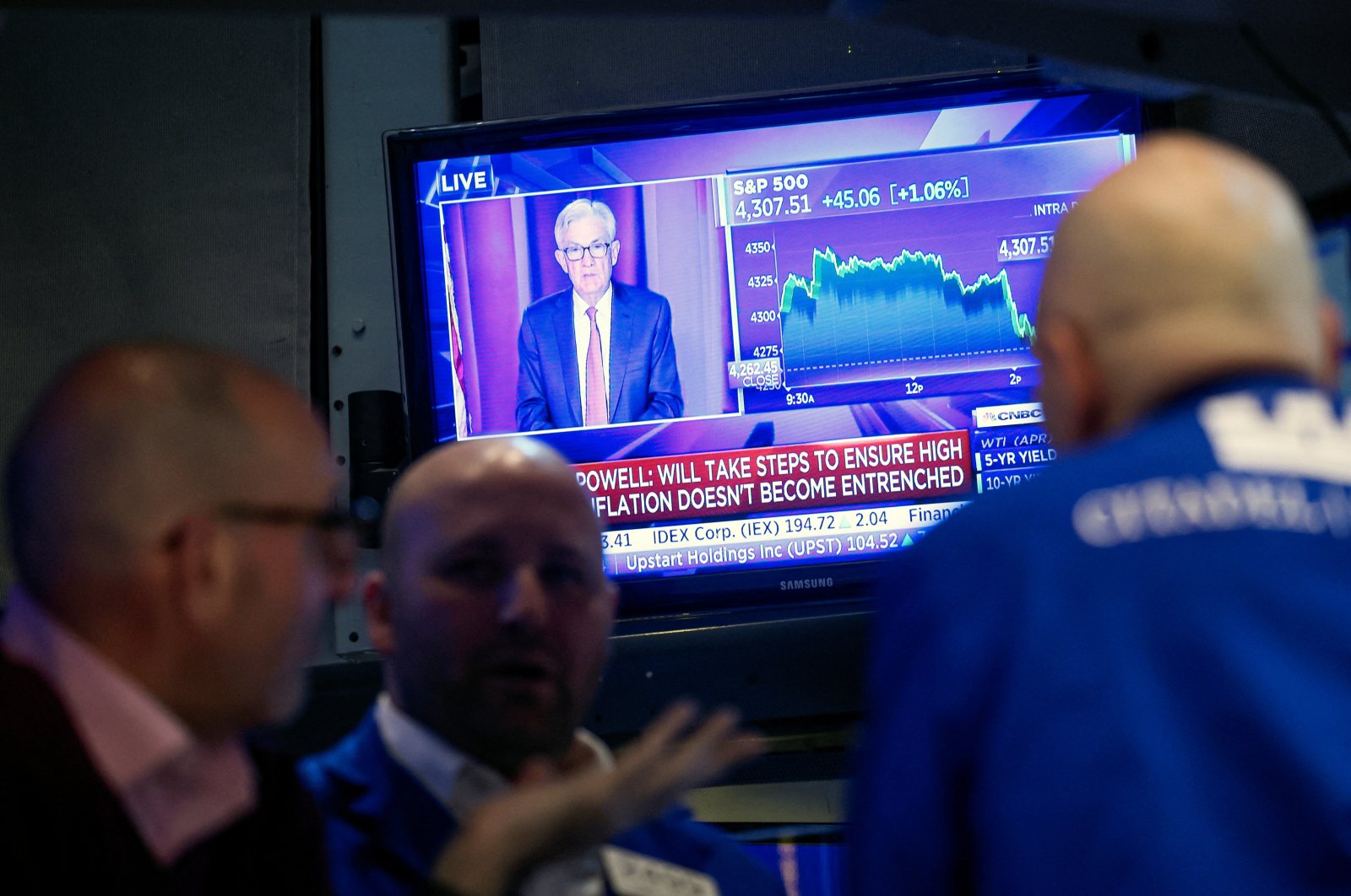Traders work as U.S. Federal Reserve (Fed) Chair Jerome Powell is seen on a screen delivering remarks, at the New York Stock Exchange (NYSE) in New York City, U.S., March 16, 2022. (Reuters Photo)
