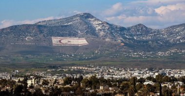 A view of snow covering a portion of Cyprus' northern Kyrenia mountain range, above the flag of the Turkish Republic of Northern Cyprus (TRNC), Lefkoşa (Nicosia), TRNC, March 13, 2022. (AFP)
