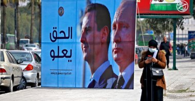 A banner depicting Syrian regime leader Bashar Assad (L) and Russian President Vladimir Putin reading "Justice Prevails" is displayed along a highway in Damascus, Syria, March 8, 2022. (AFP Photo)