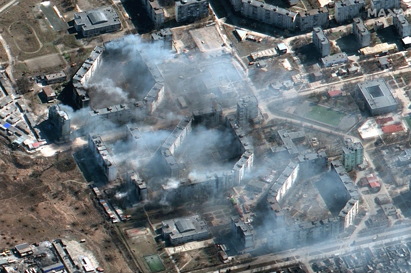 This satellite image provided by Maxar Technologies shows burning apartment buildings in northeastern Mariupol, Ukraine during the Russian invasion, March 19, 2022. (Maxar Technologies via AP)