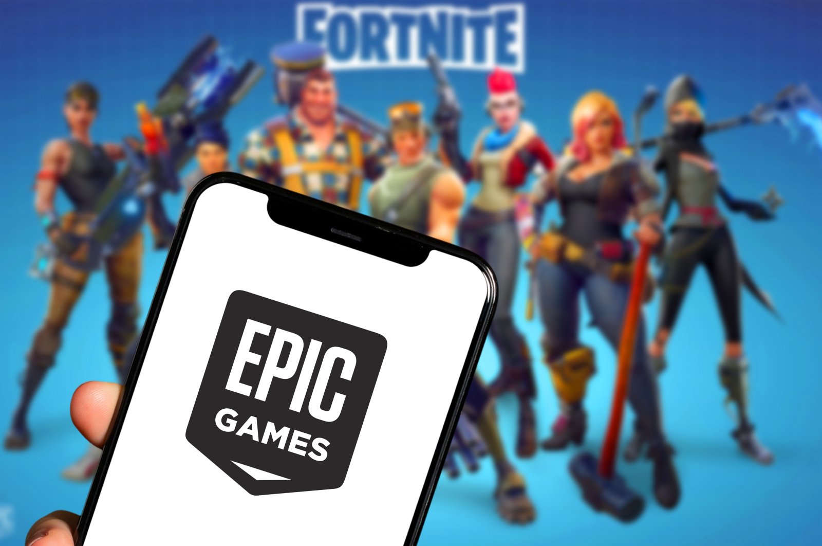 A smartphone with the logo of Epic Games is seen in front of characters from the video game Fortnite, New York, U.S., Jan. 29, 2022. (Shutterstock Photo)