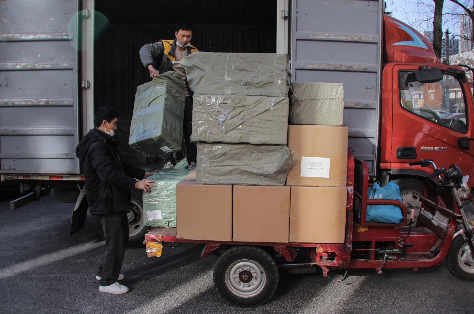 Workers unload goods from a truck near a trading center also known as Russia Market in Beijing, China, March 1, 2022. (EPA Photo)