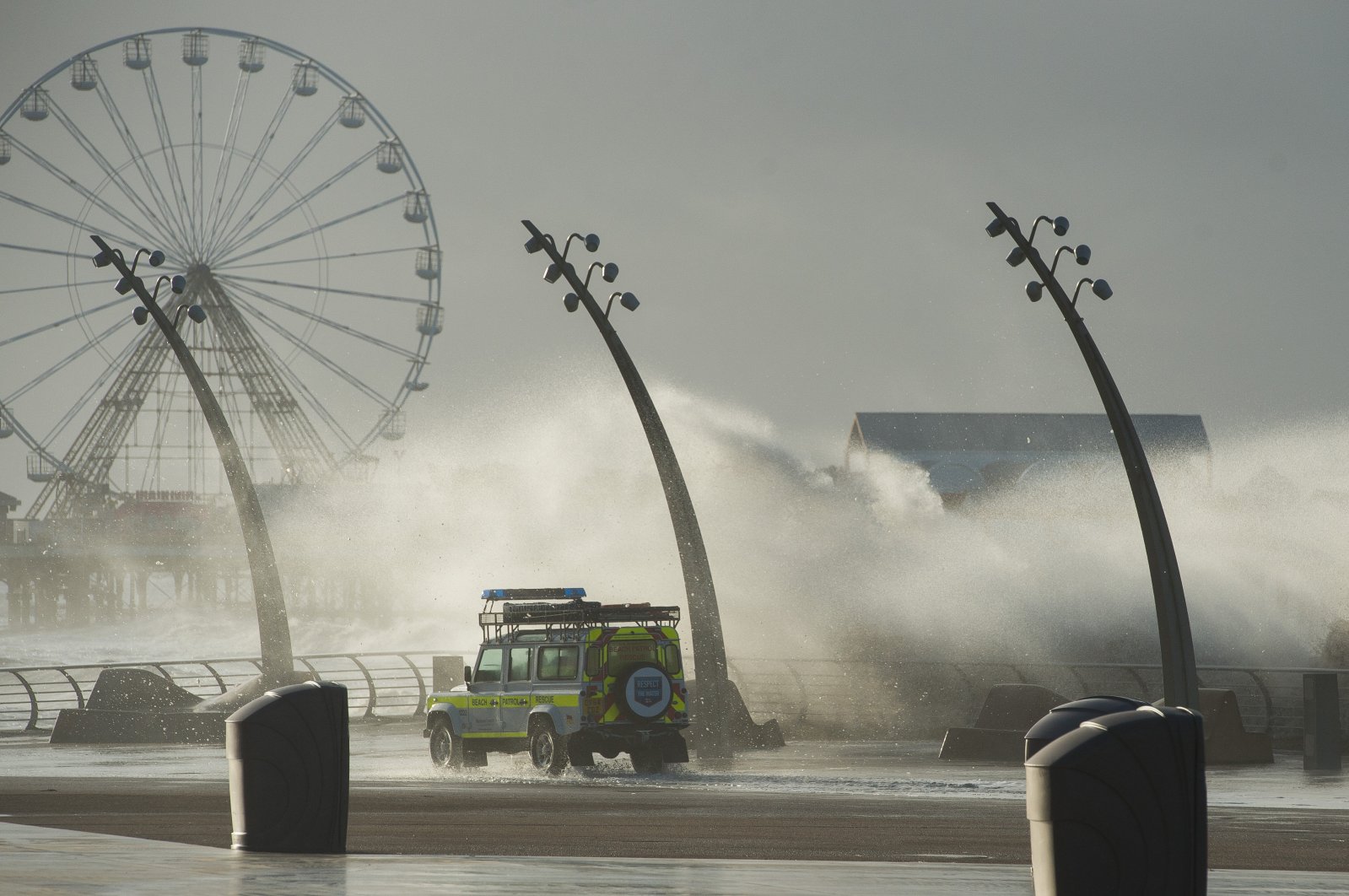 A beach patrol vehicle drives past waves crashing against the breakwater as storm Eleanor hits the coastline in Blackpool, northwest England, U.K., Jan. 3, 2018. (EPA-EFE Photo)