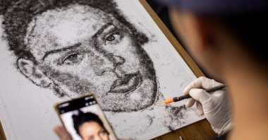 Artist and Filipino seafarer Jesstoni Garcia works on a portrait of Rihanna, made out of human hair, in San Juan City, Philippines, March 10, 2022. (REUTERS)