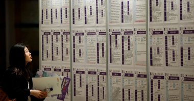 A woman looks at recruiting information during a job fair in Seoul, South Korea, April 12, 2017. (Reuters Photo)