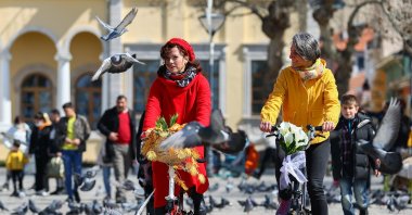 Sema Gür (L) and Pınar Pinzuti ride their bicycles at Atatürk Square, in Izmir, western Turkey, March 23, 2022. (AA Photo)