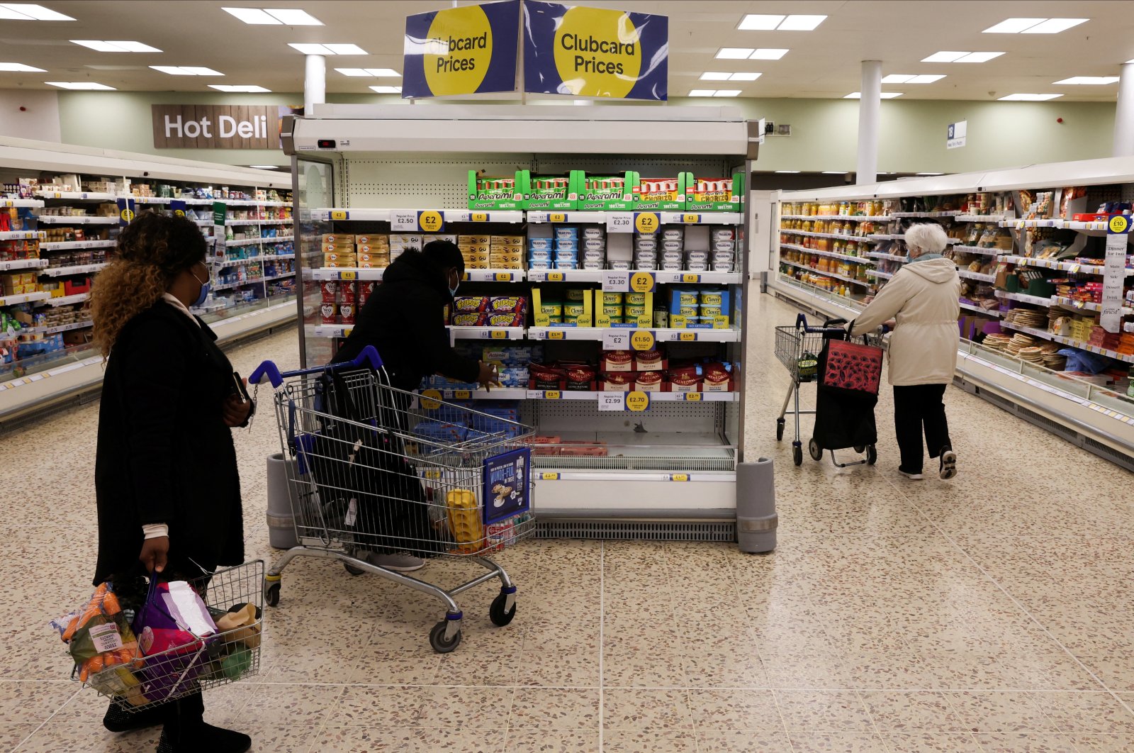People shop next to the clubcard price branding inside a branch of a Tesco Extra Supermarket in London, Britain, Feb. 10, 2022. (Reuters Photo)