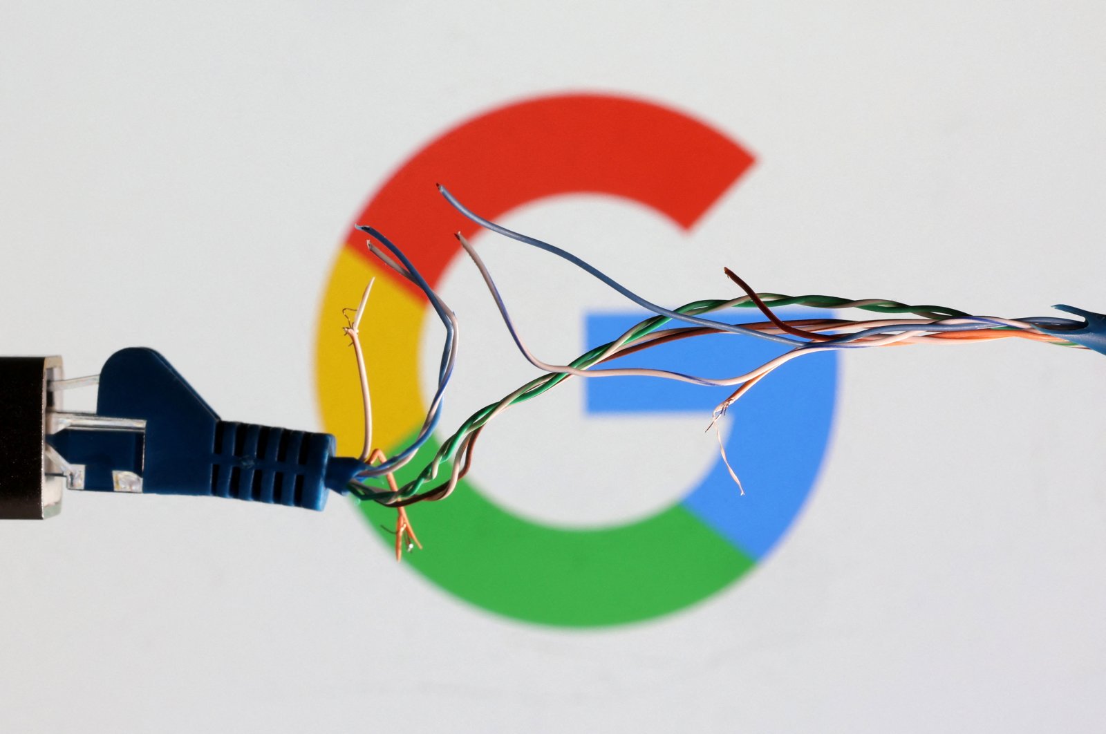 A broken ethernet cable is seen in front of the Google logo in this illustration taken March 11, 2022. (Reuters File Photo)