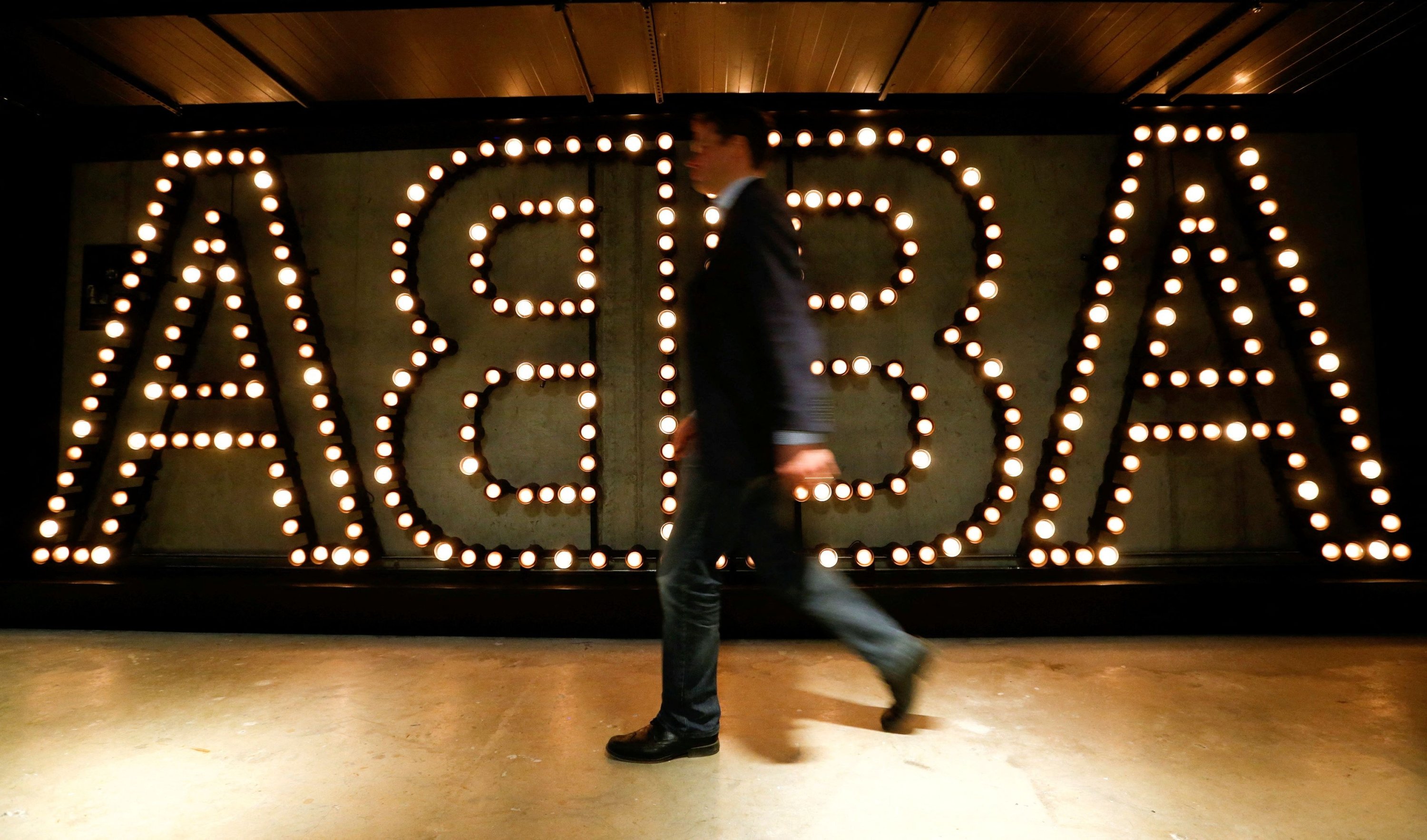 A man walks past the lit logo of the legendary Swedish pop group ABBA at the new 'ABBA - The Museum' in Stockholm, Sweden, May 6, 2013. (REUTERS)