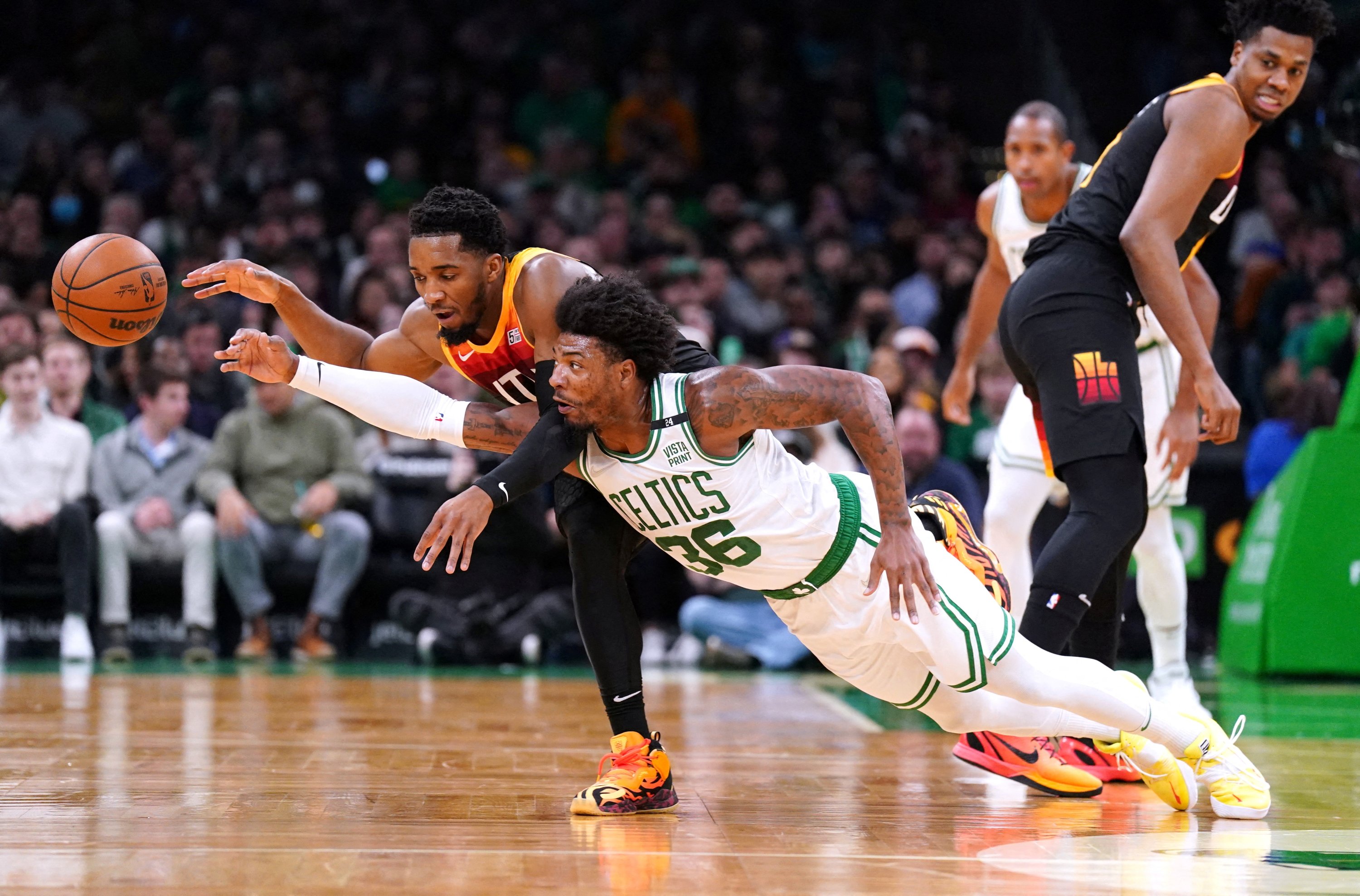 Guard Celtics Marcus Smart (kanan) dan guard Jazz Donovan Mitchell berusaha merebut bola dalam pertandingan NBA, Boston, Massachusetts, AS, 23 Maret 2022. (Foto Reuters)