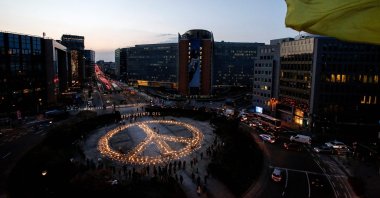 Demonstrators stand around a peace sign during a vigil for Ukraine near the European Union headquarters in Brussels, Belgium, March 22, 2022. (AFP Photo)