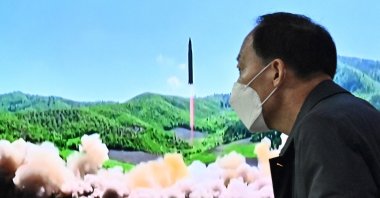 A man walks past a television report showing a news broadcast with file footage of a North Korean missile test, at a railway station in Seoul, South Korea, March 24, 2022. (AFP Photo)