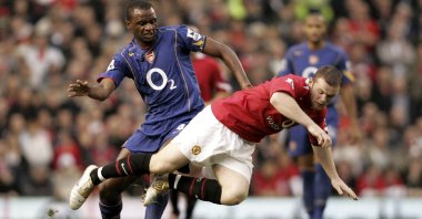 Man Utd's Wayne Rooney (R) tumbles over after a challenge by Arsenal's Patrick Vieira during a Premier League match, Manchester, England, Oct. 24, 2004.
