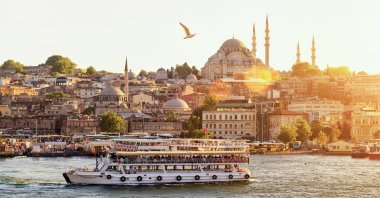 Istanbul at sunset, while tourist boat sails on the Golden Horn (Haliç), Istanbul, Turkey. (Shutterstock Photo)