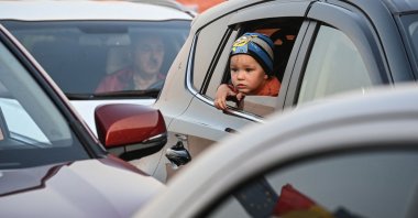 An Ukrainian child looks out of a car at the Romanian-Ukrainian border Isaccea-Orlivka on March 24, 2022. (Photo by Daniel MIHAILESCU / AFP)