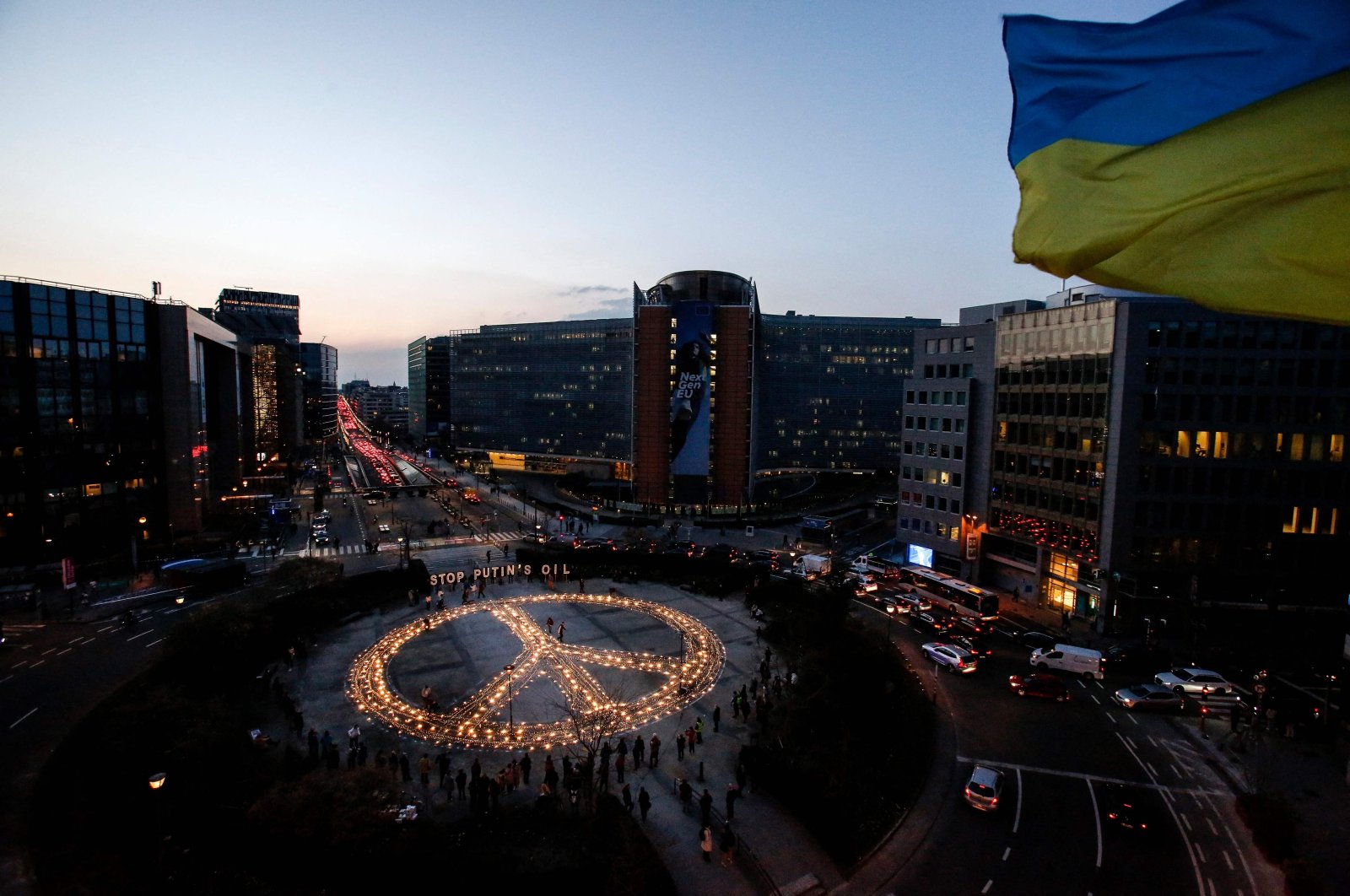 Demonstrators stand around a peace sign during a vigil for Ukraine near the European Union headquarters in Brussels, Belgium, March 22, 2022. (AFP Photo)