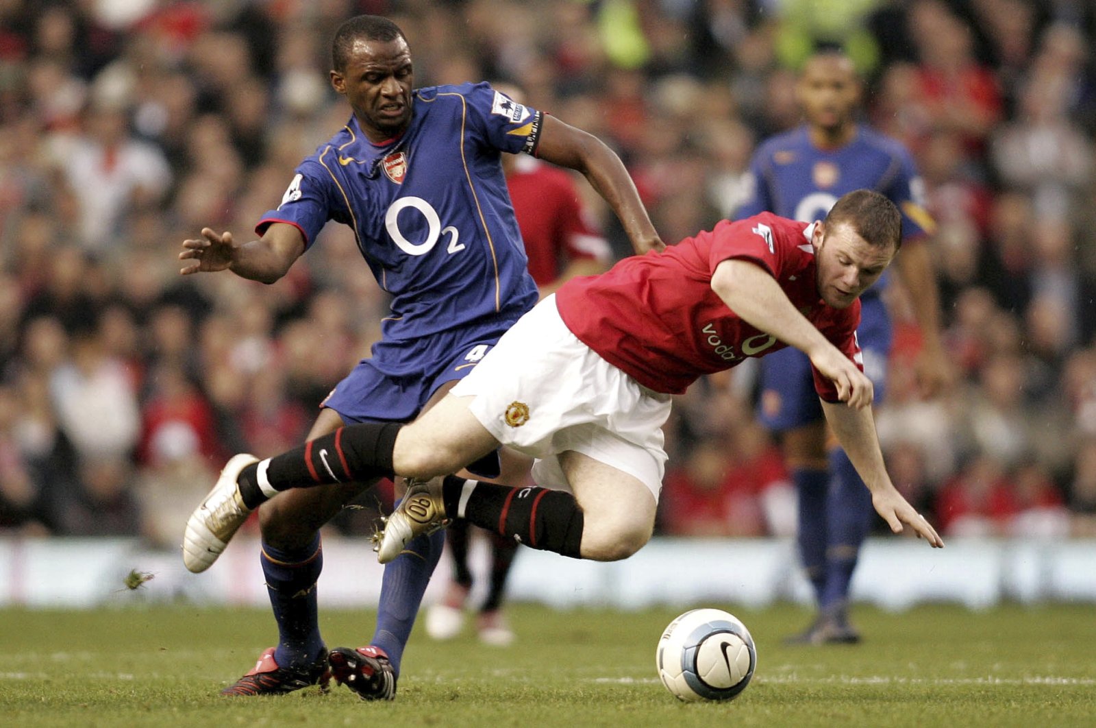 Man Utd&#039;s Wayne Rooney (R) tumbles over after a challenge by Arsenal&#039;s Patrick Vieira during a Premier League match, Manchester, England, Oct. 24, 2004.