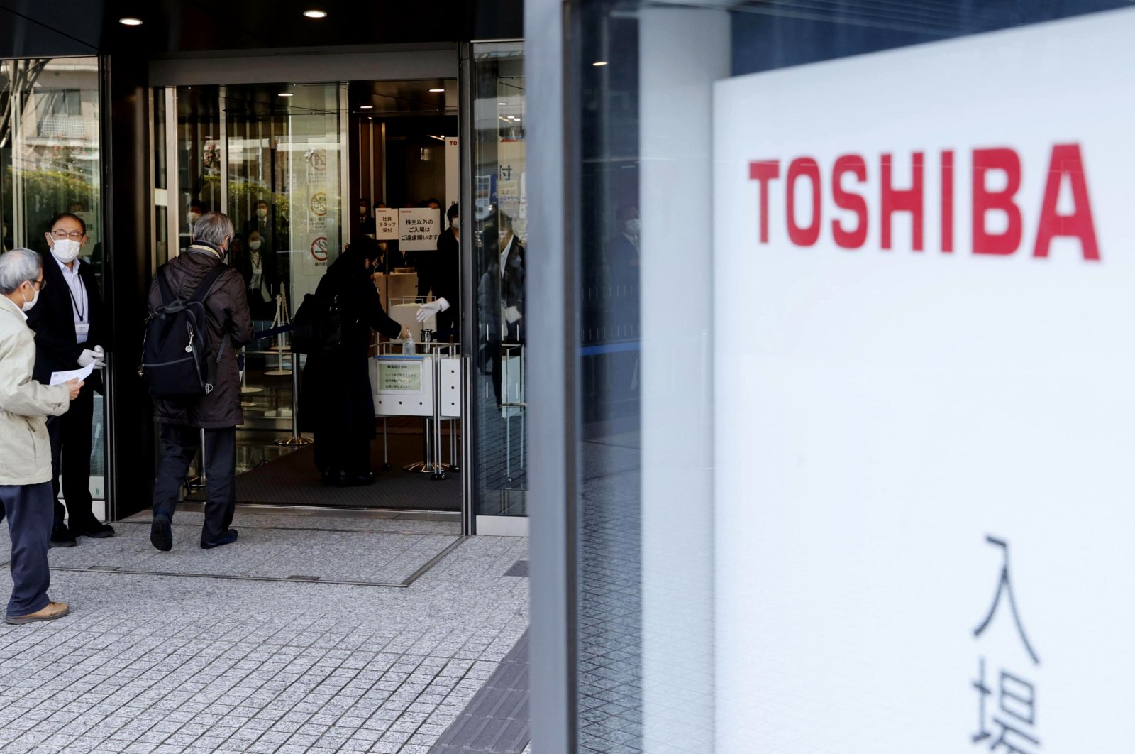 People enter the building where Toshiba Corp. held its extraordinary shareholders’ meeting in Tokyo, Japan, March 24, 2022. (Kyodo News via AP)