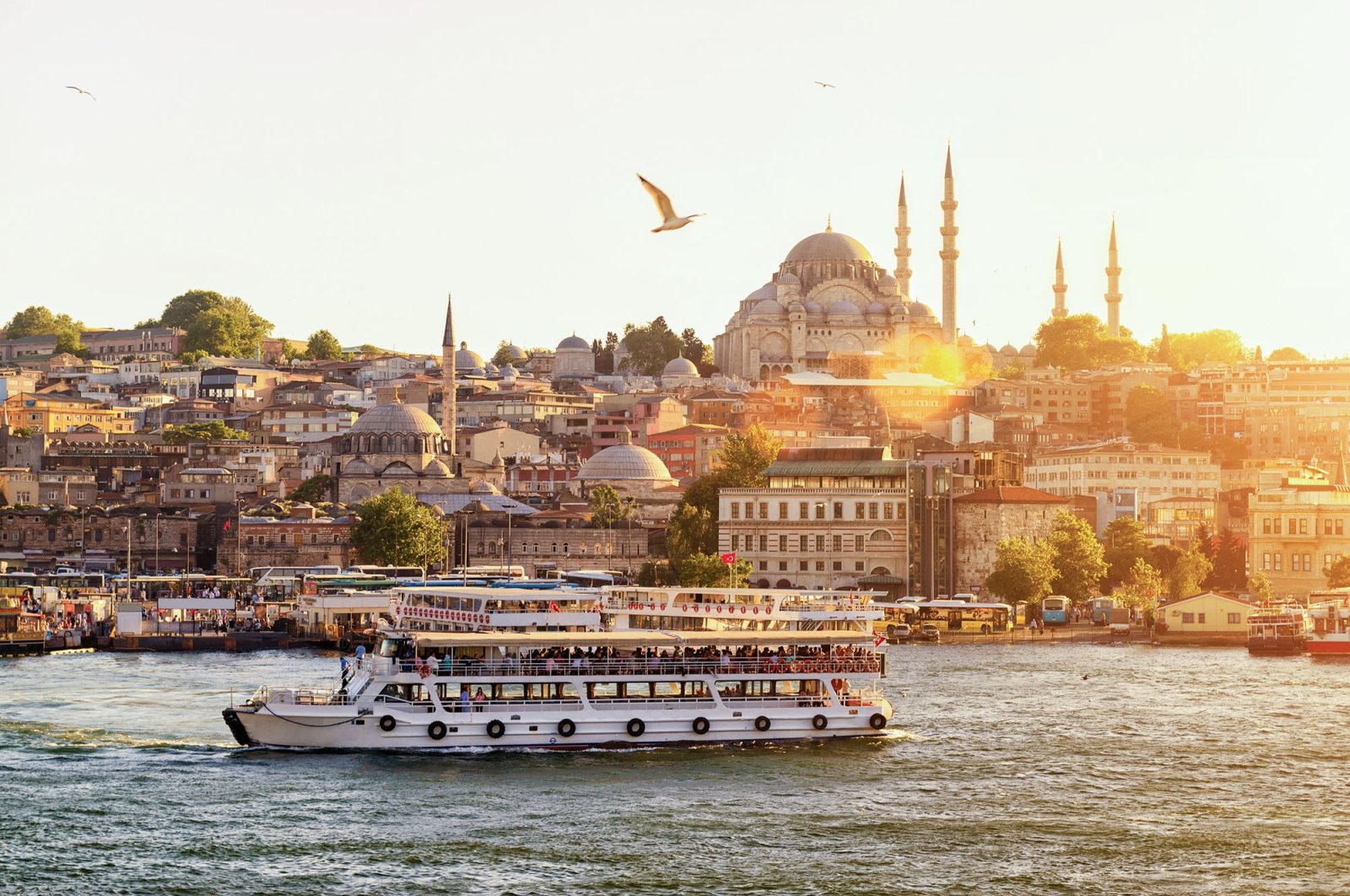 Istanbul at sunset, while tourist boat sails on the Golden Horn (Haliç), Istanbul, Turkey. (Shutterstock Photo)
