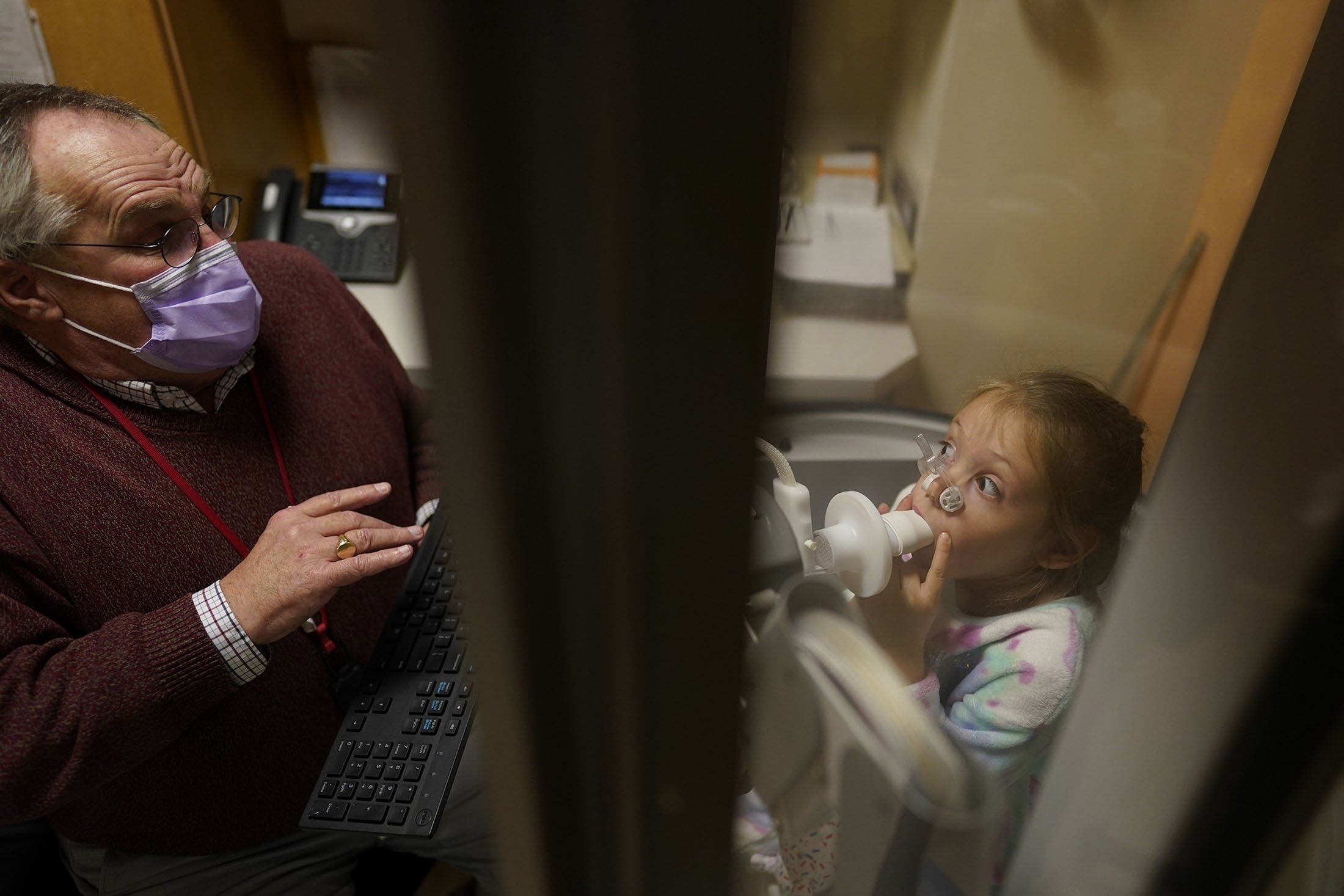 Lexie Forte, 6, melihat ke terapis pernapasan Tm Murray dari dalam ruang plethysmography selama tes fungsi paru di Children's National Hospital, di Washington, AS, 26 Januari 2022. (AP Photo)