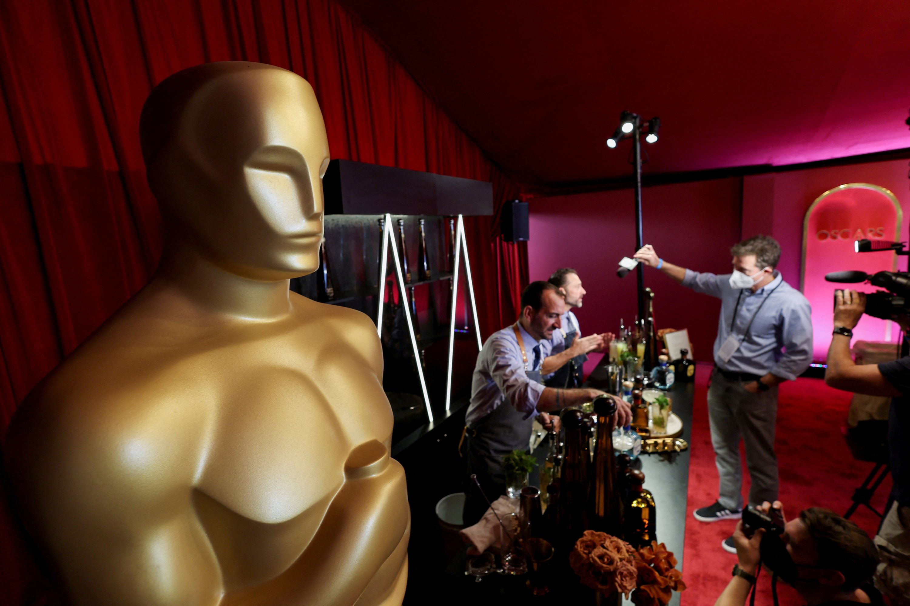 Pemandangan umum dari patung Oscar terlihat saat awak media berbicara dengan seorang bartender selama preview makanan, minuman dan dekorasi dari Governors Ball tahun ini, perayaan resmi Academy pasca Oscar setelah upacara Oscar ke-94 di Los Angeles, California , AS 24 Maret 2022. (REUTERS)