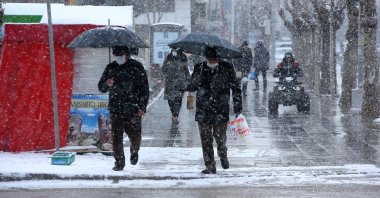 People walk amid snowfall in Çorum, central Turkey, March 20, 2022. (AA PHOTO)