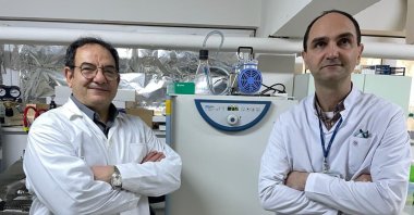 Professor Adnan Yüksel Gürüz (L) and associate professor Mert Döşkaya, a developer of the vaccine, pose in the lab, in Izmir, western Turkey, March 24, 2022. (AA Photo)